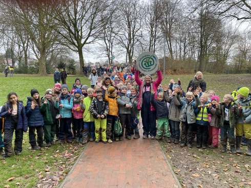 Mit Schild an Schule